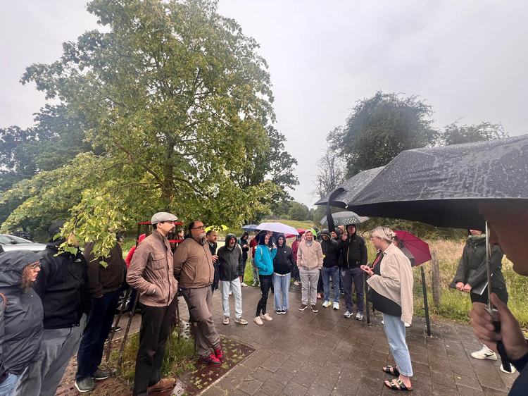 A group of people outside listening to a guide